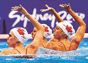 The Canadian synchronized swimming team raise their arms over their heads as they perform their routine during a training session at the Olympic Aquatic Center on Tuesday