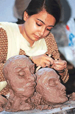 �HANDS ON CLAY: A Government Arts College student engrossed in a sculpture workshop in the college on Wednesday.&nbsp;