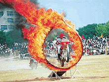 A daredevil of the Corps of Signals motor cycle stunt team jumps through a fire hoop during the Army Show to mark the 53rd Raising Day of the Western Command at Panchkula on Saturday.