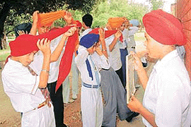 Participants exhibit their skills in a turban-tying contest in Guru Nanak Senior Secondary School, Sector 30-B, Chandigarh, on Saturday. 