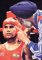 Indian boxer Suresh Soubam Singh receives instructions from his coach Gurbakhsh Singh Sandhu (R) during his men's 48 kilogram round 1 bout against Korea's Kim Ki-suk at the Sydney Olympic Games. Kim won the bout on points.    REUTERS/Peter Mueller