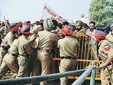 Policemen try to prevent students from storming the main pandal of the annual kisan mela