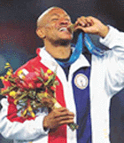 Maurice Greene from the USA bites his gold medal.