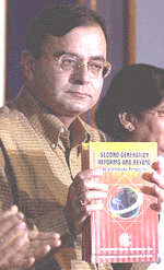 Law Minister Arun Jaitley holds up a copy of "Second Generation Reforms and Beyond" during a press conference on Monday.