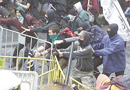 Anti-IMF protesters remove police barriers to break through a police cordon outside the congress centre in Prague on Tuesday where the IMF and the World Bank are holding their annual meeting