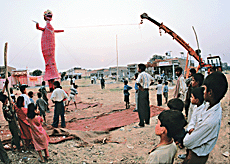 Curious children look at the erection of the effigies of Ravana, Meghnad and Kumbhkarna with the help of a recovery van at Sector 32 in Chandigarh on the eve of Dasehra.