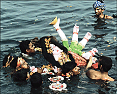 Devotees immerse an idol of Goddess Durga into the Yamuna.