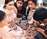 Women get mehndi applied on their hands for Karva Chauth in Chandigarh.