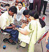Women in Ludhiana get mehndi applied on their hands on the eve of the Karva  Chauth festival. 