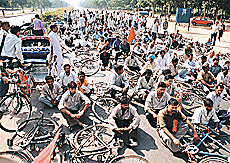Members of the Chandigarh Footpath Workers Rozgar Bachao Samiti block the road at the Housing Board roundabout in Sector 17 on Monday. 