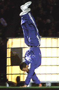 A lone athlete walks along on his hands as he enters Stadium Australia during the closing ceremony for the Paralympics in Sydney on Sunday.
