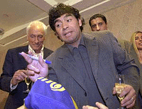 Argentine soccer legend Diego Maradona signs autographs alongside his manager Guillermo Coppola (left) during a conference in Buenos Aires on Tuesday.