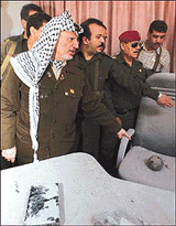 Palestinian President Yasser Arafat points to an unexploded shell that landed on a commander's chair during a tour to the rocketed headquarters of his force 17 security service in Gaza Strip on Tuesday .�  Reuters photo