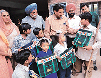 Mr Brahamjit Kalia, District Education Officer, Chandigarh, interacts with students of the night school after distributing school bags at Government High School, Sector 40, on Saturday. 