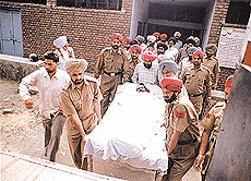 Policemen and relatives with the body of constable Jasbir Singh who was killed by suspected armed robbers, in Civil Hospital, Ludhiana, on Saturday.
