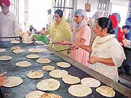 Women prepare food at a community kitchen in a gurdwara.