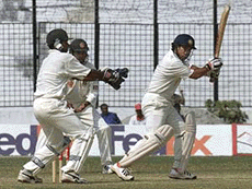 Indian batsman Sachin Tendulkar (R) hits a ball off Mohammad Rafiq (not shown) as Bangladesh wicketkeeper Shahriar Hossain (L) tries to hold a catch on the third day of the first ever Test in Dhaka's Bangabandhu Stadium on Sunday. Bangladesh gained Test status earlier this year.