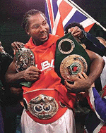 Lennox Lewis of London, England gets some help putting on his title belts after winning his WBC/IBF heavyweight championship fight against David Tua of Auckland, New Zealand on Saturday at the Mandalay Bay Events Center in Las Vegas. Lewis retained his heavyweight title with a unanimous 12 round decision.