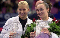 Anna Kournikova (left), of Russia, and Martina Hingis of Switzerland, hold up their trophies after winning their doubles match against Nicole Arendt and Manon Bollegraf at the Chase Championships at Madison Square Garden.