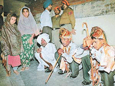 "Bridegrooms" and their father (sitting), who were arrested by the Lohgarh police under the Child Marriage Restrain Act, at the Lohgarh police post on Sunday. Also seen in the picture are the two "brides". 