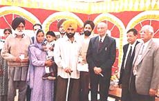 Lance Naik Jitender Singh receives a sum of Rs 50,000 in the form of Kisan Vikas Patras from the management of DMC.