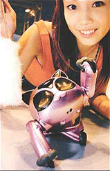 A cat shaped robot BN-1 raises its 'paw' to react against a furry cat toy (L) held by an assistant, during the robot exhibition Robodex 2000 in Yokohama, near Tokyo.
