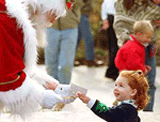 BECKLEY, US: Allison Myers, 2, of Charlotte, N.C., gives Santa a photograph of their last encounter in exchange for a honey stick on Friday.
