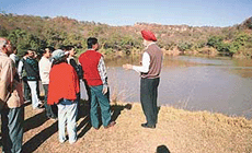 Mr H.S. Sohal, Deputy Conservator of Forests, Chandigarh, tells a team of Indian Forest Service officers about the utility of small dams in checking the siltation in the Sukhna, in Chandigarh.