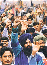 A student activist raises his fist as he shouts anti-government slogans during a mass demonstration