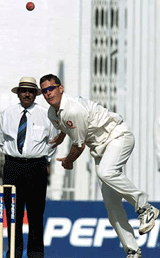 England spinner Ashley Giles bowls in front of umpire Mian Muhammad Aslam (L) during the second day of the second cricket Test against Pakistan. 