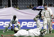 Indian bowler Reetinder Singh Sodhi (C) stops a powerful drive off Zimbabwean batsman.