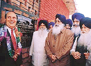 Mr Parkash Singh Badal, Chief Minister, Punjab, honours Mr Devinder S. Sidhu at the inauguration of a veterinary clinic at Barundi village near Ludhiana on Thursday.