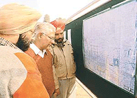 Members of the cooperative societies try to find the location of land of their societies in the map at UT State Guest House in Chandigarh.