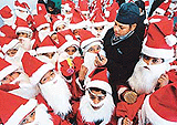 A boy applies make-up on young Santa Claus during a school Christmas celebration to mark the arrival of the festive season on Tuesday.�