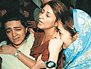 Daughters of Noor Jehan, Zillah Huma (right) and Hinna (centre), are consoled by a relative on Saturday in Karachi.