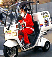 Takefumi Suzuki, an employee from the Japanese convenience store chain am/pm, rides a scooter to deliver goods ordered by customers in downtown Tokyo, on Monday. 