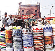 A shopkeeper with piles of cap on the eve of  Id-Ul-Fitr at Jama Masjid area in Delhi on Wednesday.