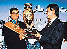 Kirsan Iliyumzhinov (R) president of FIDE hands over the World Chess Championship trophy to India's Viswanathan Anand in Tehran.