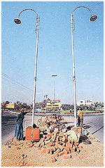 Employees of the Haryana Urban Development Authority install overhead decorative lights around a roundabout in Panchkula.