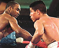 Joel Casamayor (left), WBA super featherweight champion of Miami, Florida, connects a body blow on Robert Garcia of Oxnard, California during the seventh round of their championship fight in Las Vegas on Saturday.