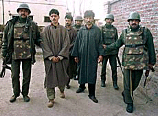 Indian paramilitary troopers escort Farooq Ahmad (3rd R) and Mohammad Saleem (2nd L) at a police station in Srinagar on January 7, 2001.
