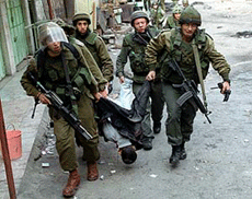 Israeli soldiers drag the body of Shaker Hassouni away from the site of clashes after he was shot dead by Israeli forces during a gunbattle in the divided West Bank city of Hebron.