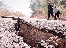 Salvadoran policemen walk down a paved street near Santa Ana.