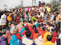 Protesters stand around the body of Suraj Bhan, alias Bau, on the GT Road