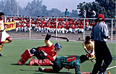 Mohammad Hosne Mubarak of Bangladesh makes a bid to outsmart Sri Lankan goalkeeper Rasika Wikramasinghe in the third Asian School Hockey Championship at Punjab Agricultural University, Ludhiana, on Saturday.