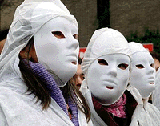 Three students wear white masks during a march in solidarity with illegal immigrants in central Madrid on Tuesday.