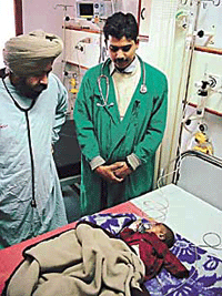 Dr Baldeep and Dr Sanjeev Gupta with the two-month-old Rattan who was operated upon for a lung disorder in Ludhiana.