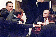 Turkish Opposition party parliamentarian Mehmet Fevzi Sihanlioglu (left) is held back by unidentified parliamentarians as fist-fighting broke out between dozens of deputies during a hot debate in Turkish assembly in Ankara late on Tuesday.