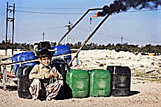 An Iraqi boy waits for customers to sell drinking water in front of an oil refinery near Basrah on Thursday.