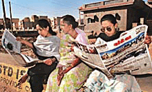 Survivors of the earthquake scan through local newspaper.